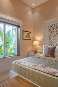 a bedroom with a large bed and a window at juSTa Luxe Kashi Parampara, Varanasi in Varanasi +219 photos