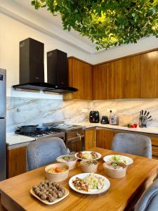 a wooden table with bowls of food on it in a kitchen at The Bunkyard Galle Hostel in Galle