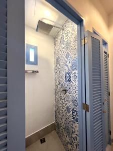a bathroom with a shower with blue and white tiles at Blau Hostel in El Nido +27 photos