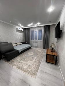 アティラウにあるПолный дом 2のベッドとソファとテーブルのある寝室