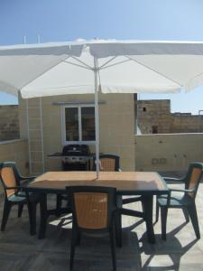 a table and chairs with an umbrella on a patio at Senglea Apartments in Senglea