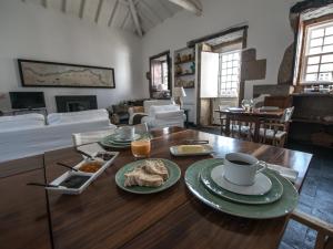 ein Wohnzimmer mit einem Tisch und Teller mit Lebensmitteln darauf in der Unterkunft Morgadio da Calcada Douro Wine&Tourism in Provesende
