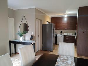 a kitchen with a table and chairs and a mirror at Sunrise Mountain Views in Krugersdorp