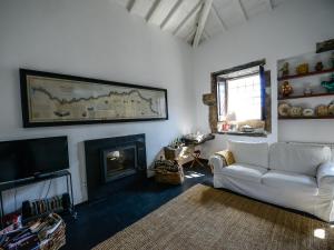 a living room with a white couch and a fireplace at Morgadio da Calcada Douro Wine&Tourism in Provesende