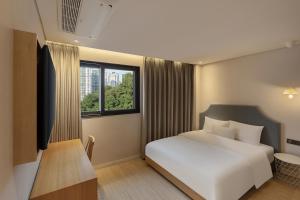 a bedroom with a white bed and a window at NewCZ Gwangan Hotel in Busan +44 photos