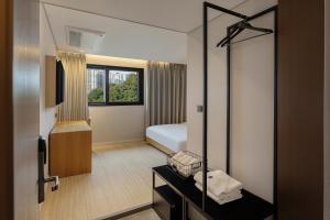 a hotel room with a bed and a mirror at NewCZ Gwangan Hotel in Busan