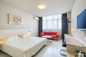 a hotel room with a bed and a red chair at Jinjiang Inn Xuzhou Peixian Hancheng Road in Pei +194 photos