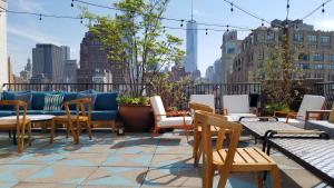 a patio with chairs and tables and a couch on a roof at SIXTY SoHo in New York