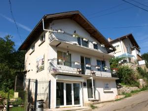 a white house with a balcony with flowers on it at Skalolazka 2 in Belogradchik