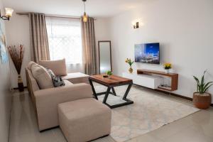 a living room with a chair and a table at Perfect Palm Condos-N12 in Nakuru