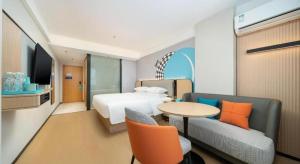 een hotelkamer met een bed, een tafel en stoelen bij City Comfort Inn Beihai Hepu Bus Terminal in Hepu