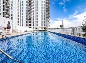 a large swimming pool in front of a building at DVH Luxe Retreats 2BR Yas Island by Ferrari World & Yas Mall in Abu Dhabi