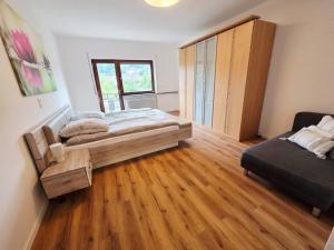 une chambre avec un lit et un canapé dans l'établissement Ferienwohnung Krone - nähe Europa-Park, Rulantica, Triberg, à Lahr/Schwarzwald