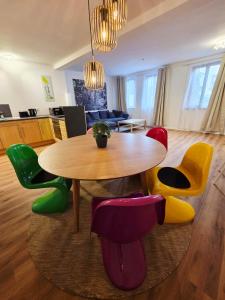 une salle à manger avec une table et des chaises colorées dans l'établissement Ferienwohnung Krone - nähe Europa-Park, Rulantica, Triberg, à Lahr/Schwarzwald