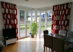 a dining room with red curtains and a dining table at Family Apartment Sonja Terrace & mountain view in Rauris