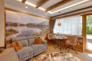 a living room with a large painting of a lake at Seefeld ALPIN - Rustikales TIROLER CHALET Studio Apartment in Seefeld in Tirol