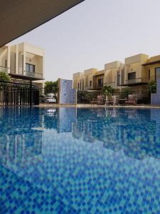 a large swimming pool in front of some buildings at 3 Bhk Villa in Prime Location in Dubai
