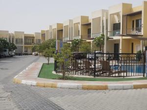 a patio with tables and chairs in front of a building at 3 Bhk Villa in Prime Location in Dubai