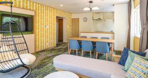 ein Wohnzimmer mit Couch und Küche in der Unterkunft Seagaia Forest Cottages in Miyazaki