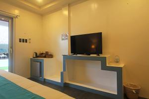 a bedroom with a flat screen tv on a wall at Amihan Resort in Panglao