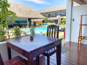 a wooden table and chair on a patio with a pool at Amihan Resort in Panglao