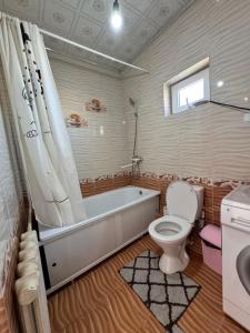 a bathroom with a tub and a toilet and a sink at MAKSAT Guest House, Horse Riding Kyzart-Song Kol in Dzhangyaryk +7 photos