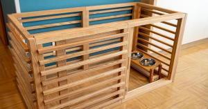 a wooden dog crate with two bowls in it at Seagaia Forest Cottages in Miyazaki