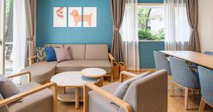 a living room with a couch and chairs and a table at Seagaia Forest Cottages in Miyazaki +45 photos