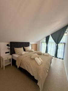 a bedroom with a large bed with two towels on it at Zen Resort and Winery in Slănic +21 photos
