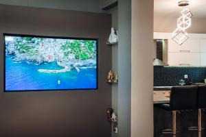 a flat screen tv hanging on a wall in a room at Luxury Suite Prada in Paleokastritsa