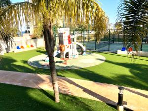 a palm tree in a park with a playground at Lucerna II, Bajo 2 in Dehesa de Campoamor