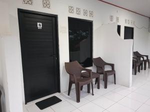 a row of chairs and a door in a building at Jajapin Hotel putri Sari in Tjikakaka