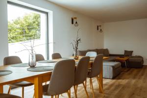a dining room with a table and chairs and a couch at Sunset Hills Chalet in Slănic