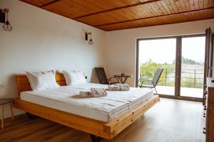 a bedroom with a large bed with a large window at Sunset Hills Chalet in Slănic