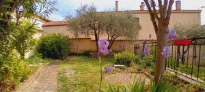 Un jardín con flores moradas delante de una valla. en Sweet villa view 26, en Nyons