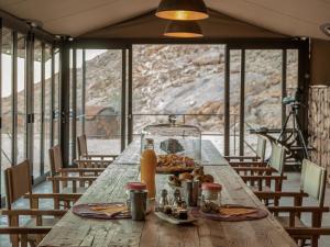 a wooden table with a plate of food on it at Camp Sossus in Sesriem