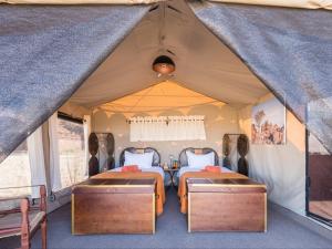 a tent with two beds and a table in it at Camp Sossus in Sesriem