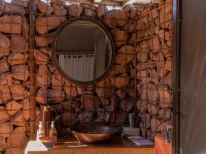 a bathroom with a mirror and a sink at Camp Sossus in Sesriem +32 photos
