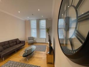 a living room with a couch and a mirror at Travaal.©om - 2 Bed Serviced Apartment Farnborough in Farnborough