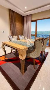 Un comedor con mesa y sillas de madera. en The Meriton, en Jāmb