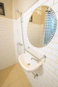a white bathroom with a sink and a mirror at Nunia TamanSari Hotel in Kumprung