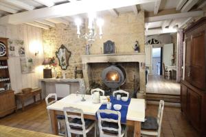 a dining room with a table and a fireplace at Gîte Lamarmette, calme et confort, piscine privative, borne VE in Lanquais