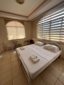 1 dormitorio con 1 cama blanca grande y ventanas en DDD Habitat Inc Iloilo, en Iloilo City