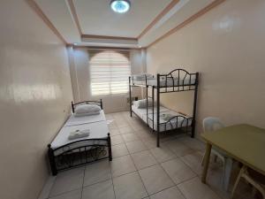 una habitación con dos literas y una mesa en DDD Habitat Inc Iloilo, en Iloilo City