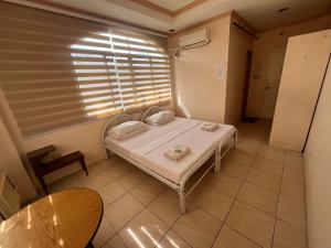 Un dormitorio pequeño con una cama y una ventana. en DDD Habitat Inc Iloilo, en Iloilo City