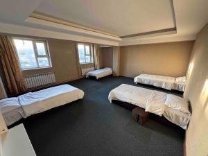 a room with three beds and two windows at Summer hostel in Ulaanbaatar