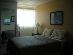A bed or beds in a room at Ocean Front Apartment