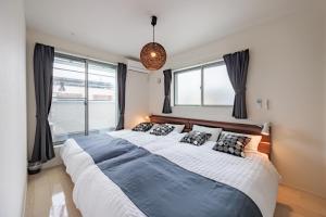 a large bed in a bedroom with windows at House FORMOSA熱田 in Nagoya