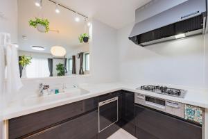 een keuken met een wastafel en een spiegel bij House FORMOSA熱田 in Nagoya +44 foto's