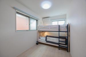 een kamer met twee stapelbedden en een raam bij House FORMOSA熱田 in Nagoya